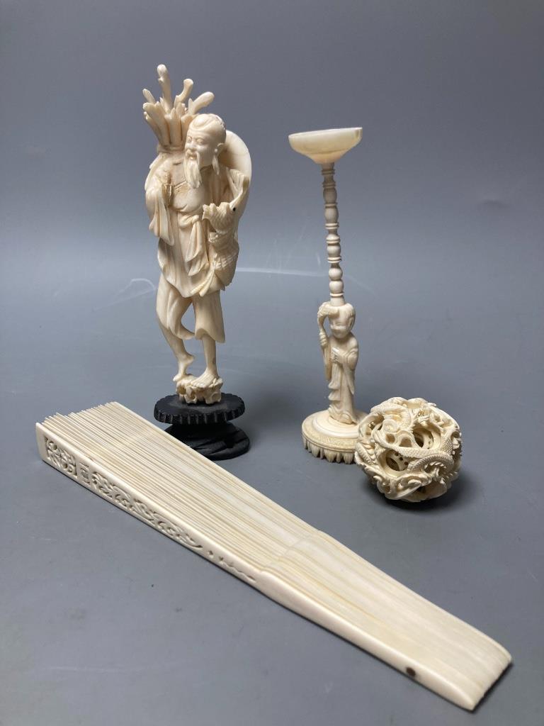 A carved Chinese ball on stand, a brise fan and a Japanese carved figure